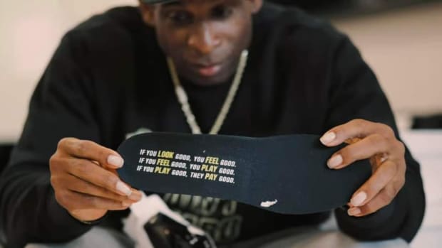 Deion Sanders hold Nike Diamond Turf 3 shoes